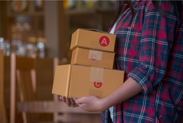 A woman holding delivery boxes to be delivered