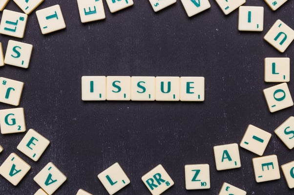 Issue scrabble letters arranged over black backdrop