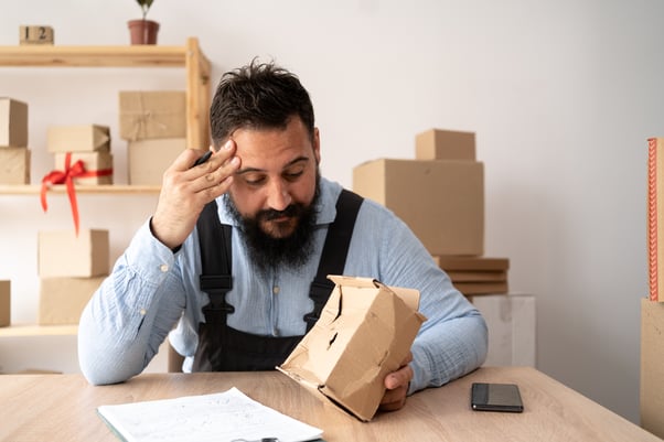 Seller is in tension with the courier package in his hand.